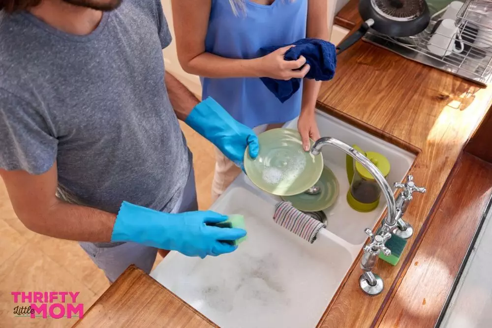 Couple doing dishes together from adult chore chart