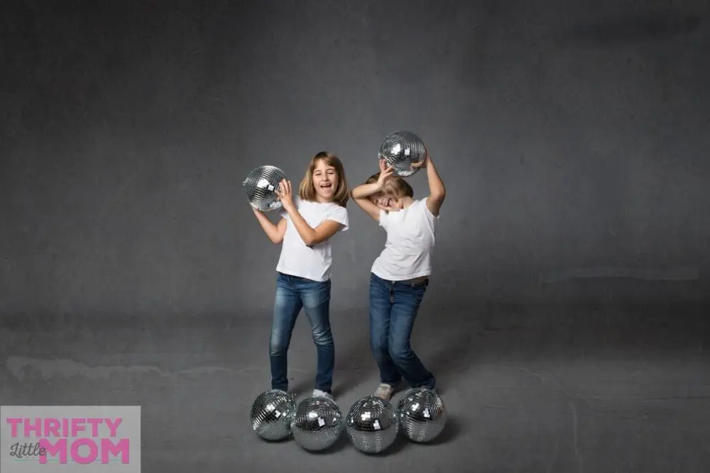 two kids playing with disco balls for a kids disco party